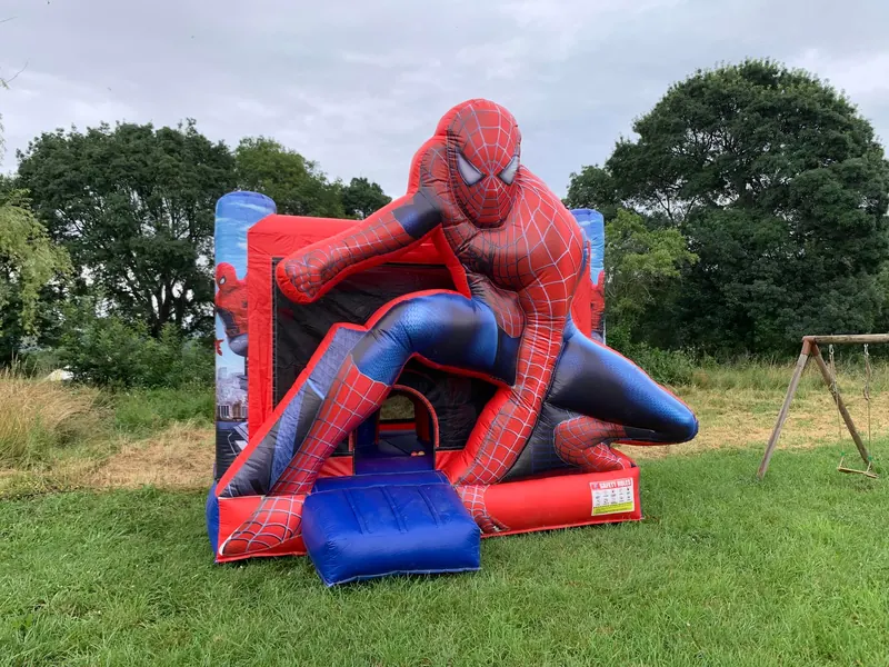 Château gonflable Spiderman monté dans un jardin